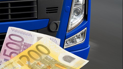 Ein 500-Euro-Schein und ein 200-Euro-Schein vor einem Lkw symbolisieren, dass die Nichteinhaltung von Regelungen schnell teuer werden kann.