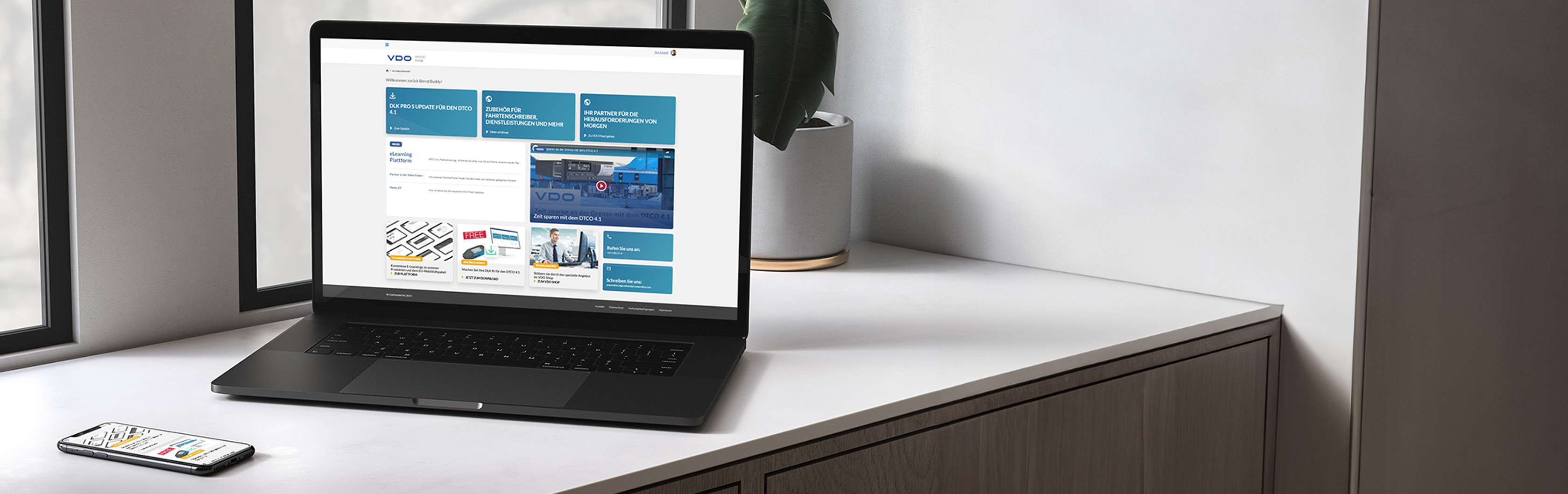 Das Bild zeigt einen Laptop und ein Smartphone auf einer weißen Fensterbank, auf denen jeweils der Homescreen der My VDO Anwendung zu sehen ist. Die Anwendung ist die optimale Anlaufstelle für alle Flottenbetreiber, die auf der Suche nach Leitfäden, E-Learnings und aktuellen Informationen sind. )