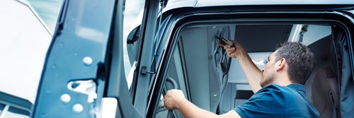 Ein Fahrer steckt einen VDO Download Key in den vorgesehenen Steckplatz am Tachographen seines Lkw.